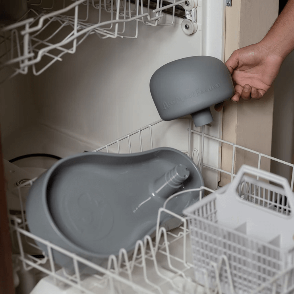 Grey AniMoat being placed into an open dishwasher.